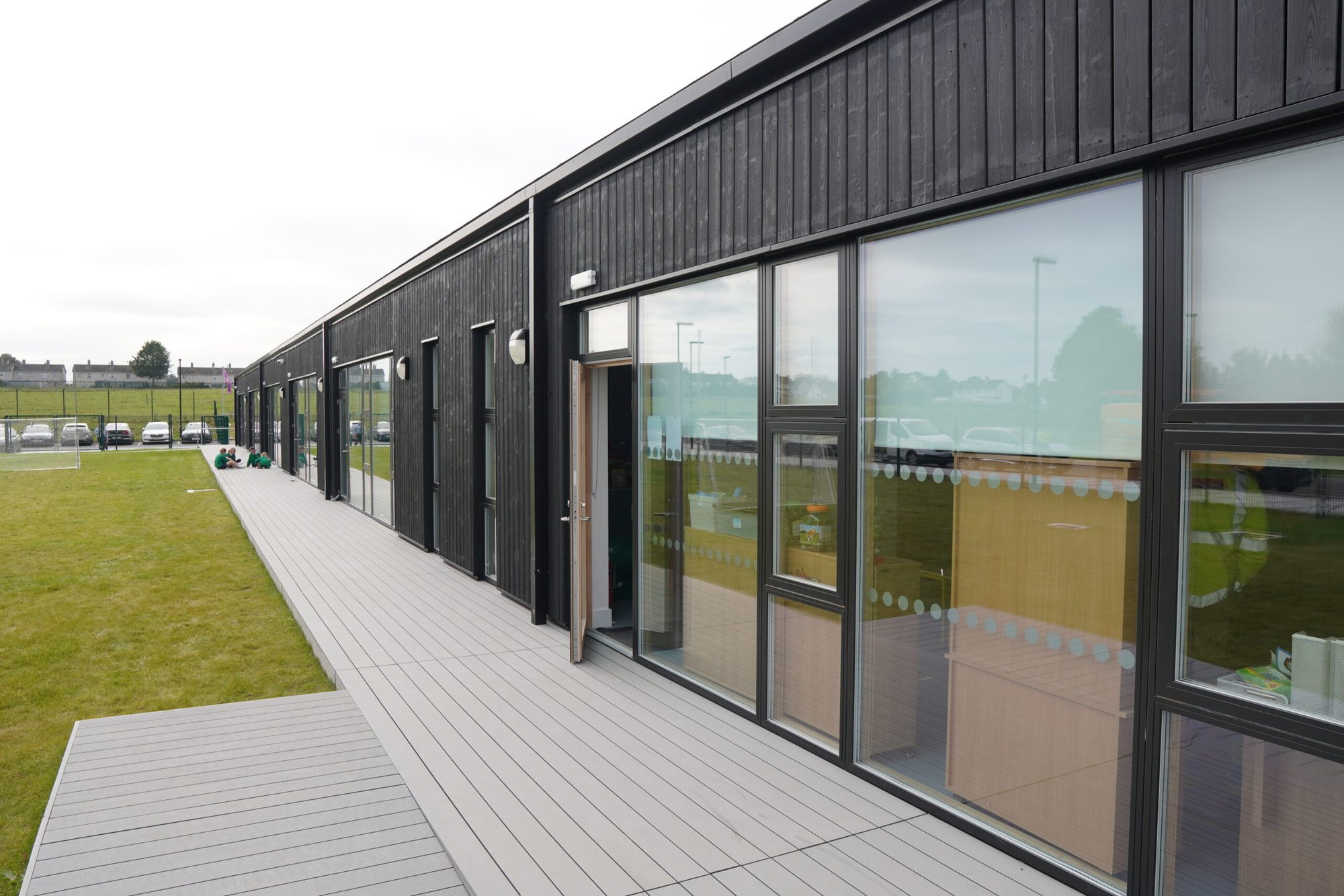 Black timber-clad school building by Lidan
